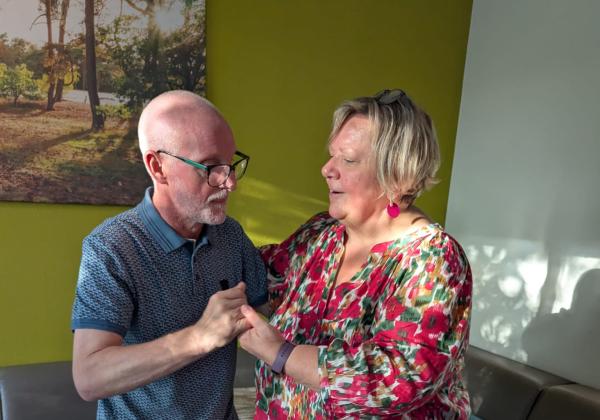 Ingrid en Marc dansen en zingen in de woonkamer